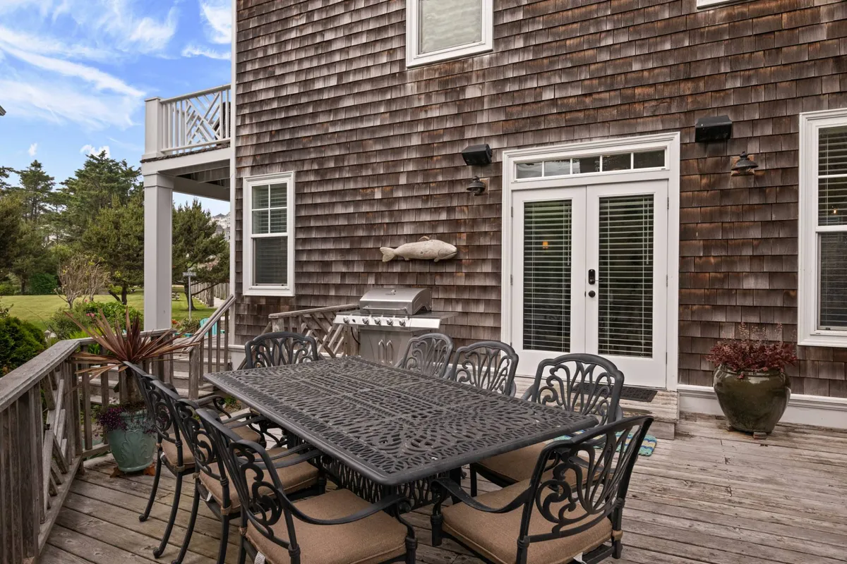 The photo highlights a wooden deck with a dining table and grill, adorned with planters and a playful fish decoration. It’s set up for outdoor meals or social gatherings in the fresh air, suggesting an easy transition between home comforts and outdoor adventures.